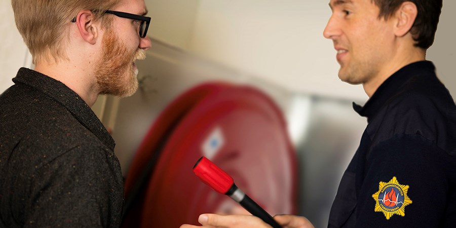 Brandinspektör kontrollerar brandskydd tillsammans  med verksamhetsutövare