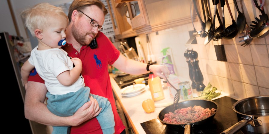 Pappa och barn lagar mat i köket